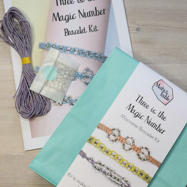 Beaded macrame bracelet kit packaging and contents, showing lilac cotton cord, full colour instruction leaflet and packet of beads