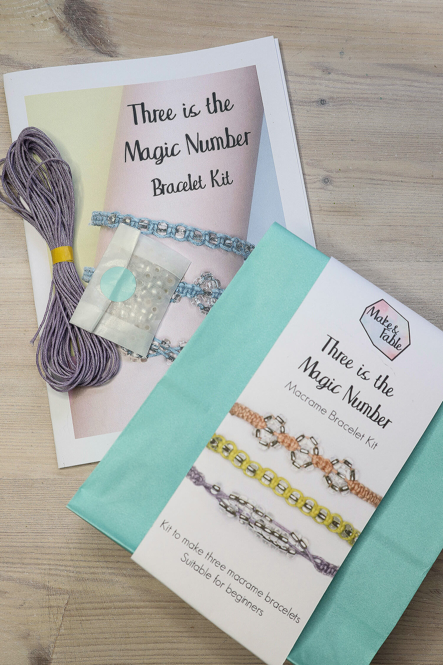 Beaded macrame bracelet kit packaging and contents, showing lilac cotton cord, full colour instruction leaflet and packet of beads