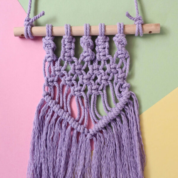 macrame wall hanging in lilac on a pastel background