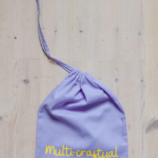 Colourful cotton project bag, lilac with a yellow print of the word multicraftual.