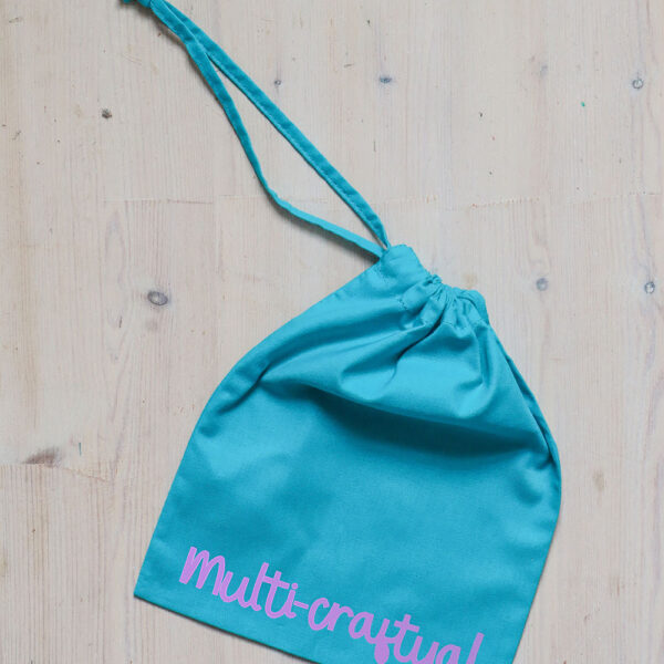 Colourful cotton project bag, teal with a lilac print of the word multicraftual.