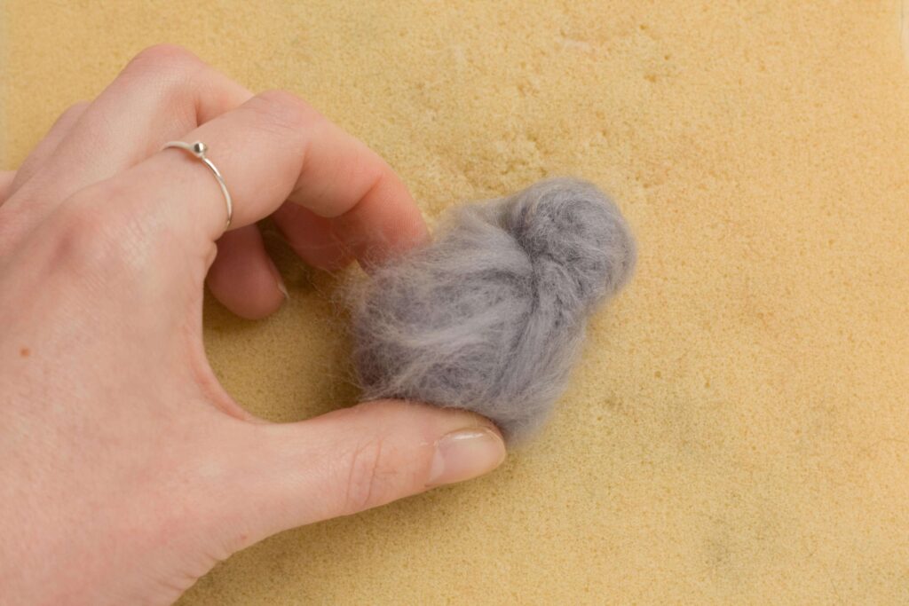 Needle Felt Bunny Rabbit Tutorial the smaller grey ball of roving has been added onto the larger ball. The loose fibres have been splayed out over the larger ball.