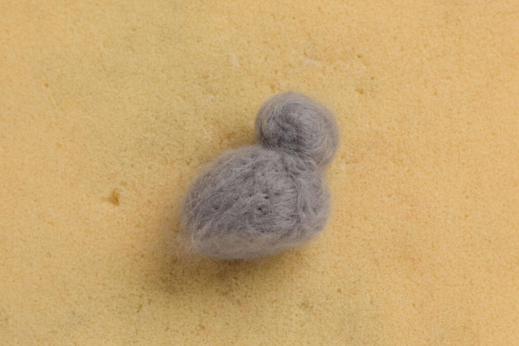 The smaller ball is now attached to the body to form a head. The base of the body has been flatted out, so the bunny sits upright. The smaller ball is now attached to the
