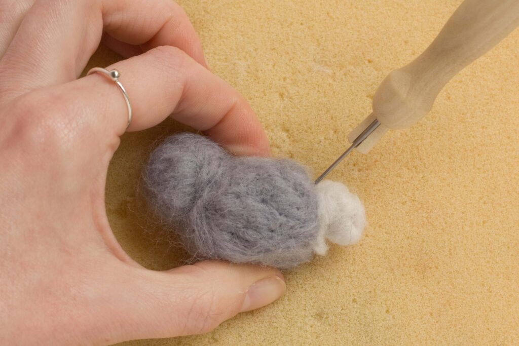 Needle Felt Bunny Rabbit Tutorial a small ball of white roving being attached to the rear of the body