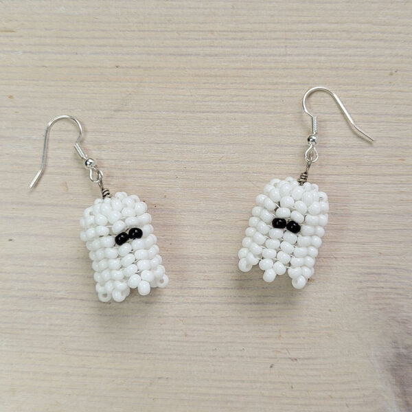 Beaded ghost earrings on a wooden background