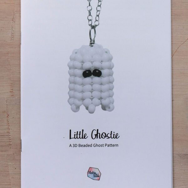 Beaded ghost pattern printed booklet on a wooden background