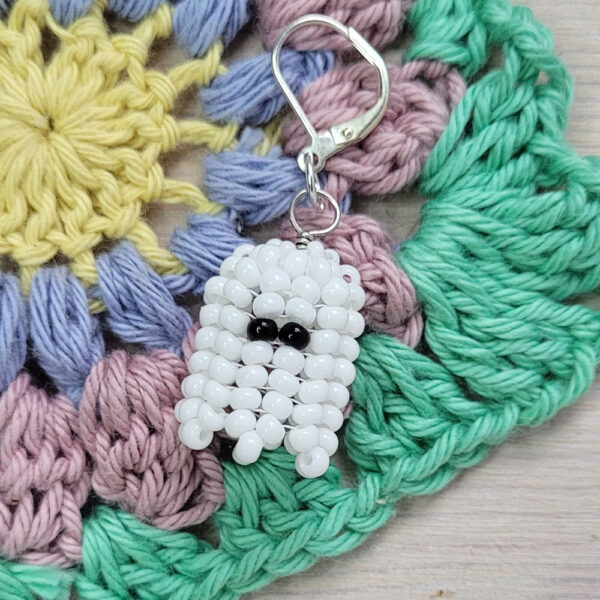 A beaded ghost stitch market sits on a corner of a crochet granny square