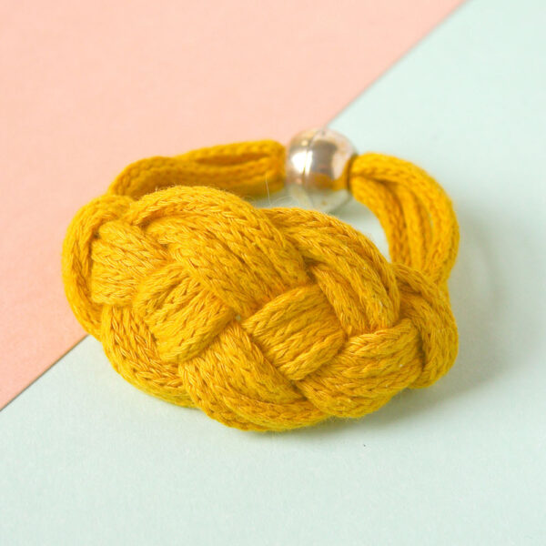 An example of hte Carrick Cuff macrame bracelet pattern in braided yellow cord