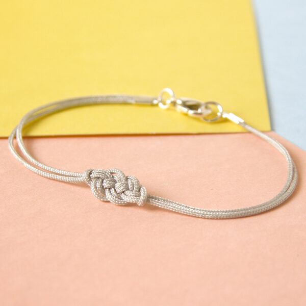 an example of the Carrick Cuff macrame bracelet pattern, made in finer pale gray cord