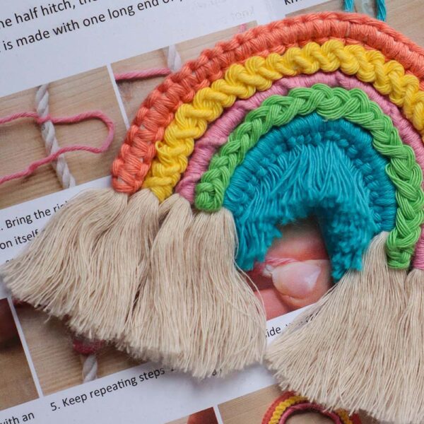 close up of a macrame rainbow sat on the instruction booklet