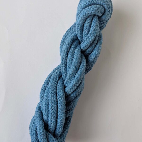 A skein of blue 10mm macrame cord on a white background