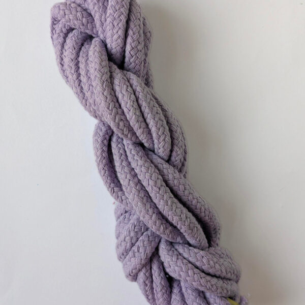 A skein of lilac 10mm macrame cord on a white background