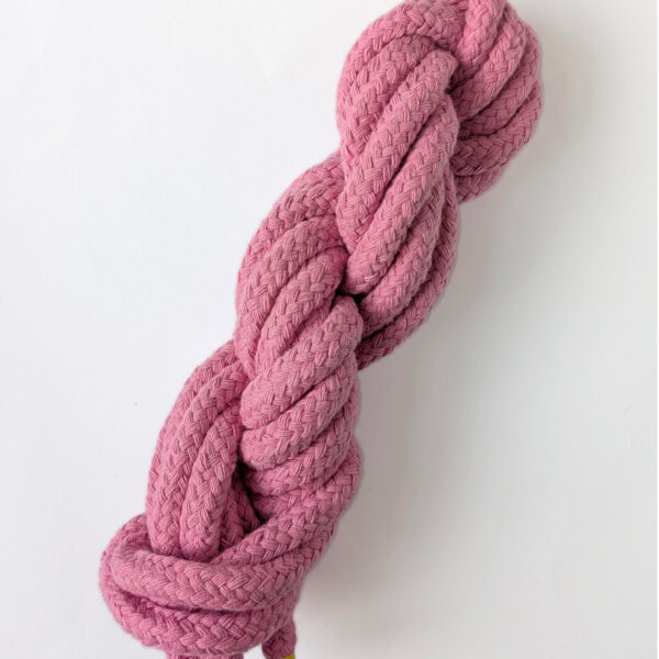 A skein of pink 10mm macrame cord on a white background