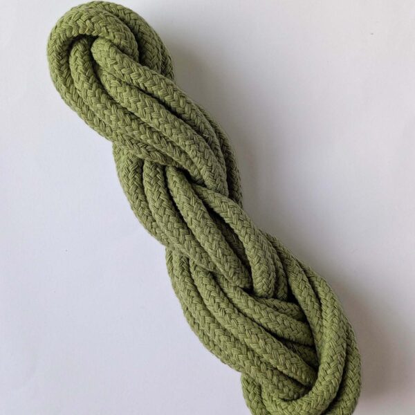 A skein of sage green 10mm macrame cord on a white background