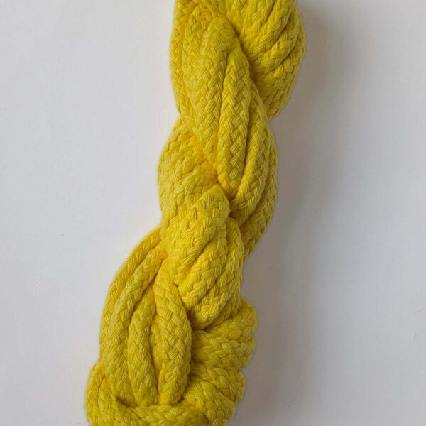 A skein of yellow 10mm macrame cord on a white background