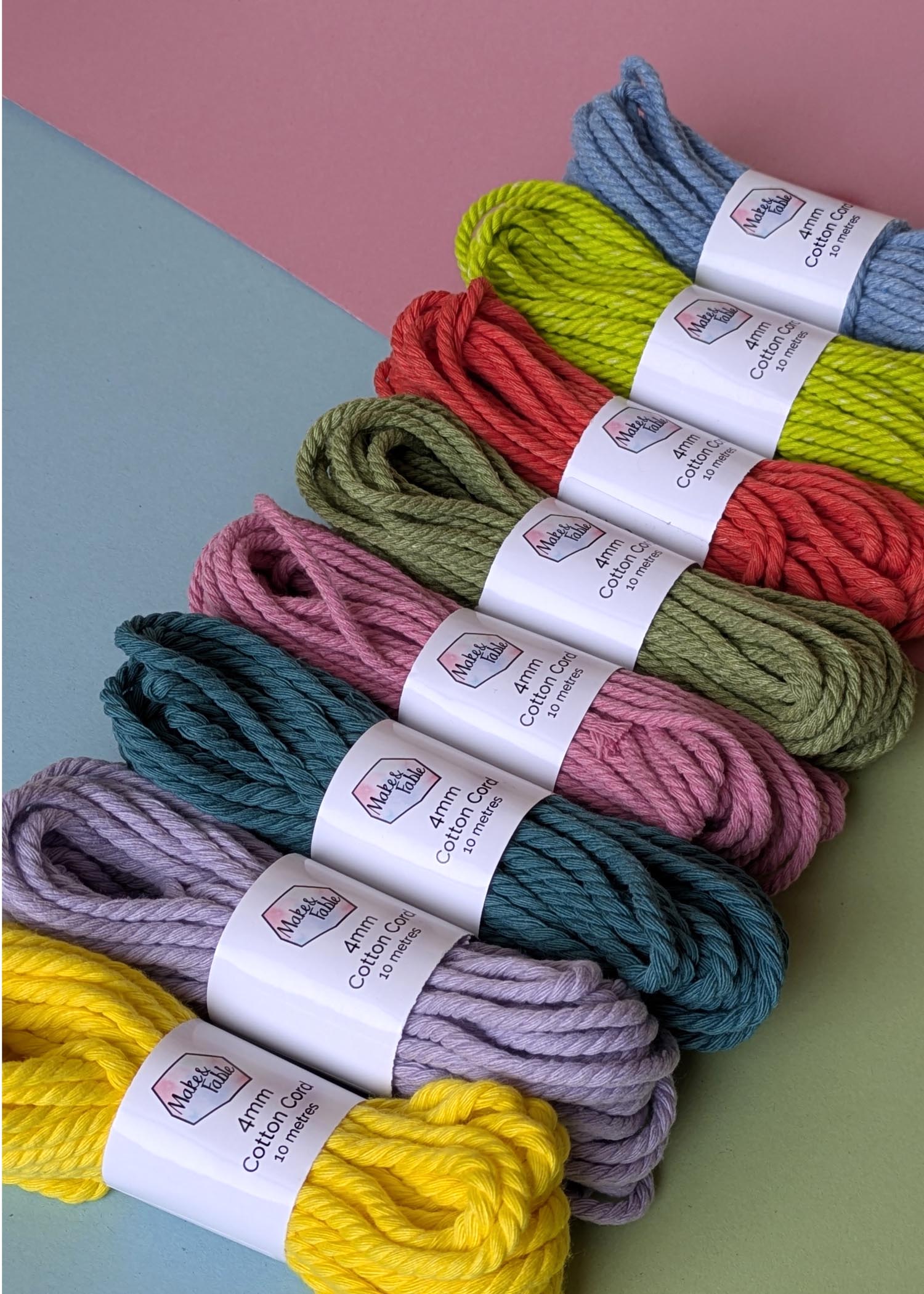 Bundles of 4mm macrame cord in a row, on a pastel background