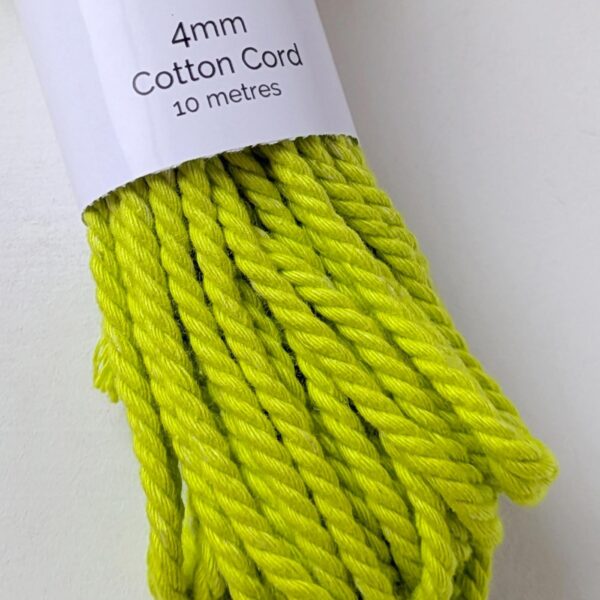 Close up of a bundle of 4mm macrame cord in a bright, almost neon green