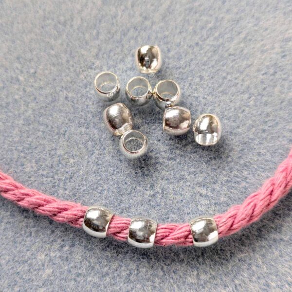 6mm metal beads, with a large hole. Some are threaded onto 4mm macrame cord