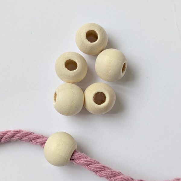 12mm wooden beads, with a natural finish and a large hole, with one threaded into macrame cord