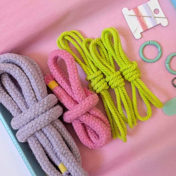 Macrame lanyard kit contents in bright. A rope lanyard in lilac, rose pink and neon green with a turquoise fixings and phone tether tab